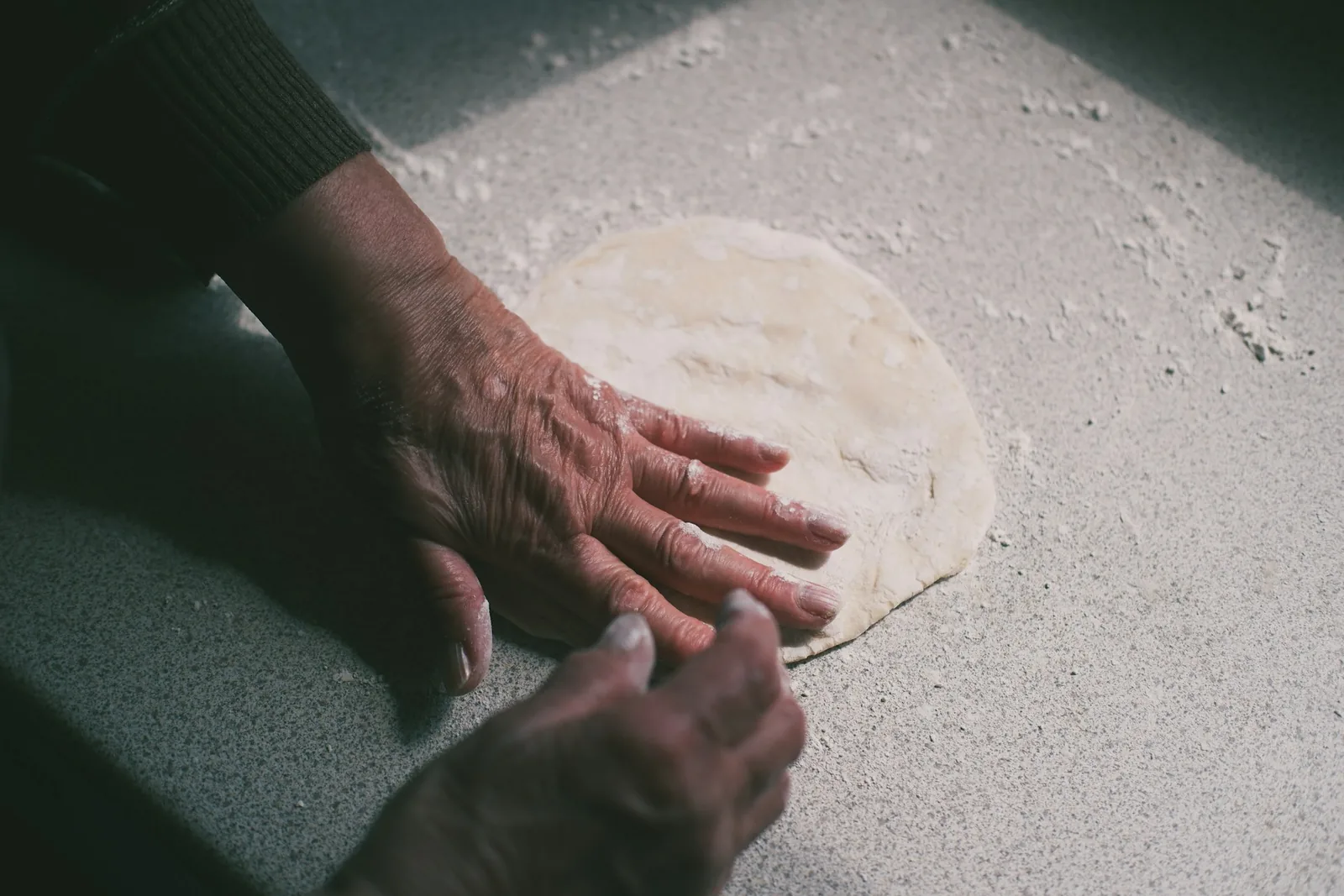 Hands folding and crimping a dough edge