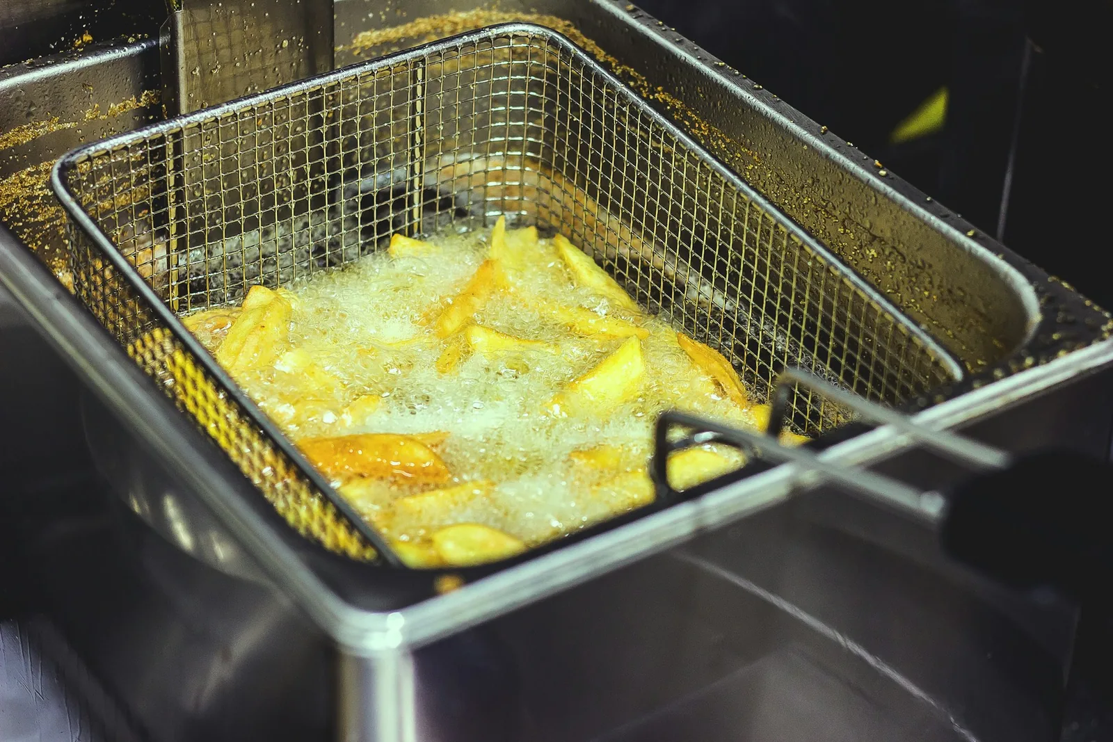 A fryer basket being lifted
