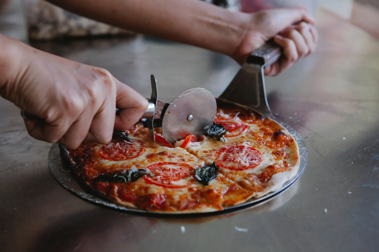 A pizza being cut