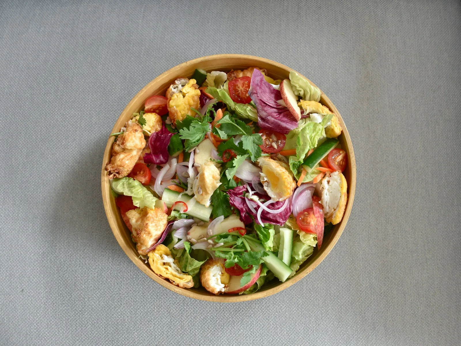 A salad topped with grilled chicken