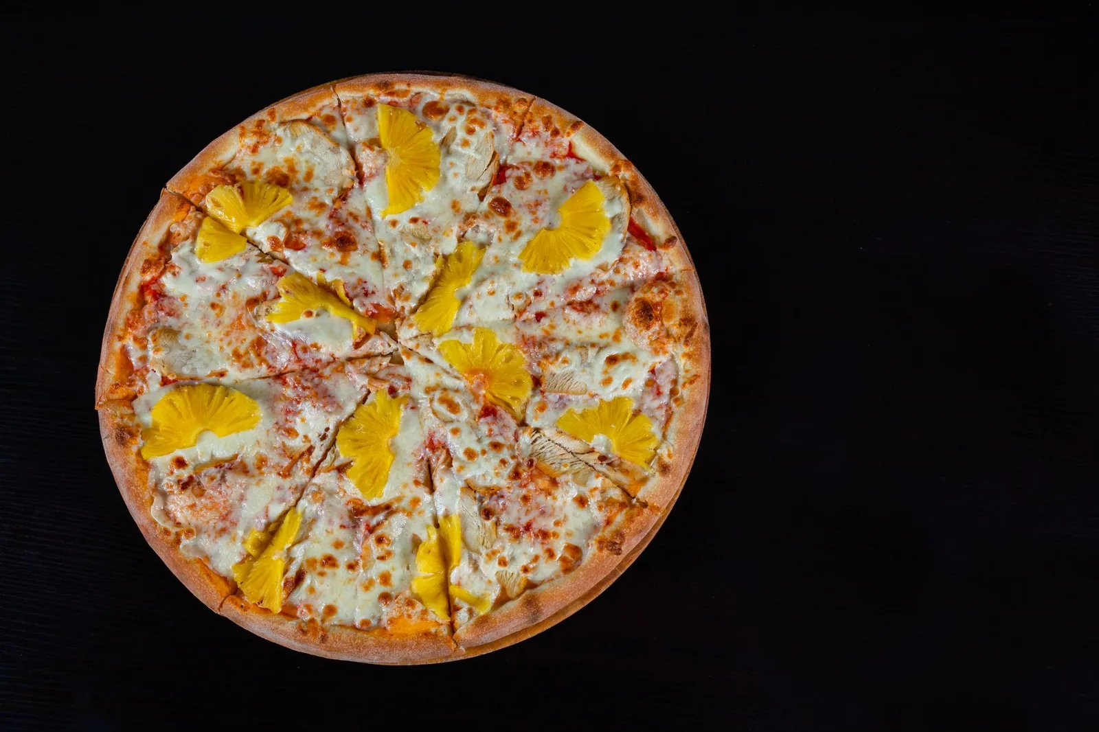 A pizza on a dark surface