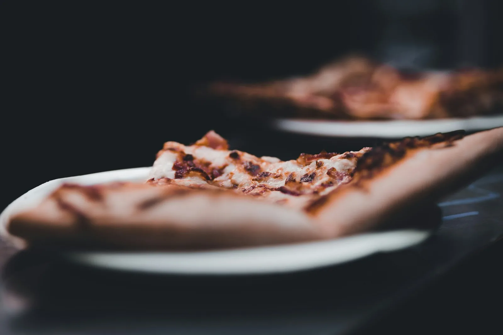 A pizza slice on a dark background
