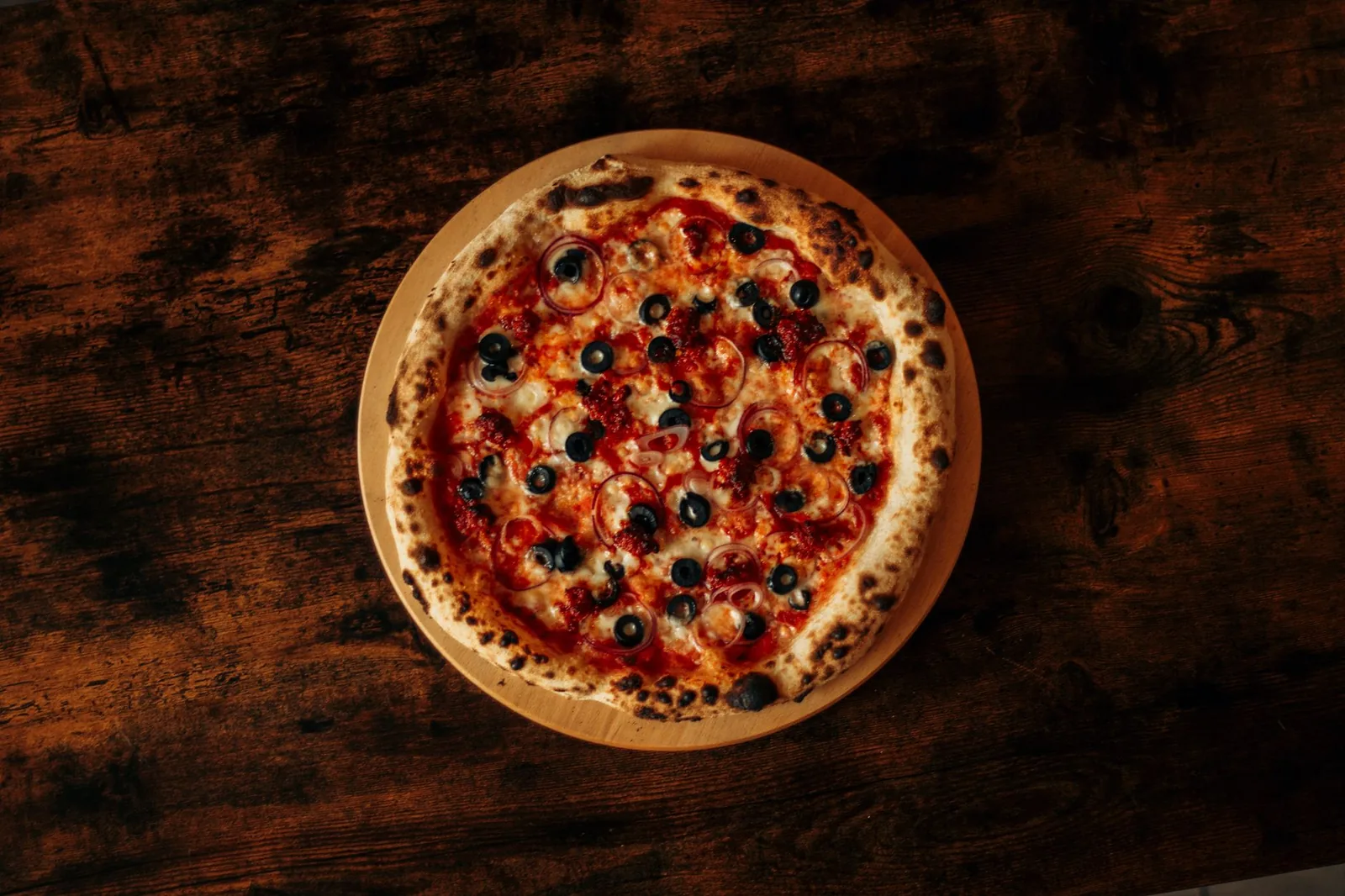 A pizza on a dark rustic surface