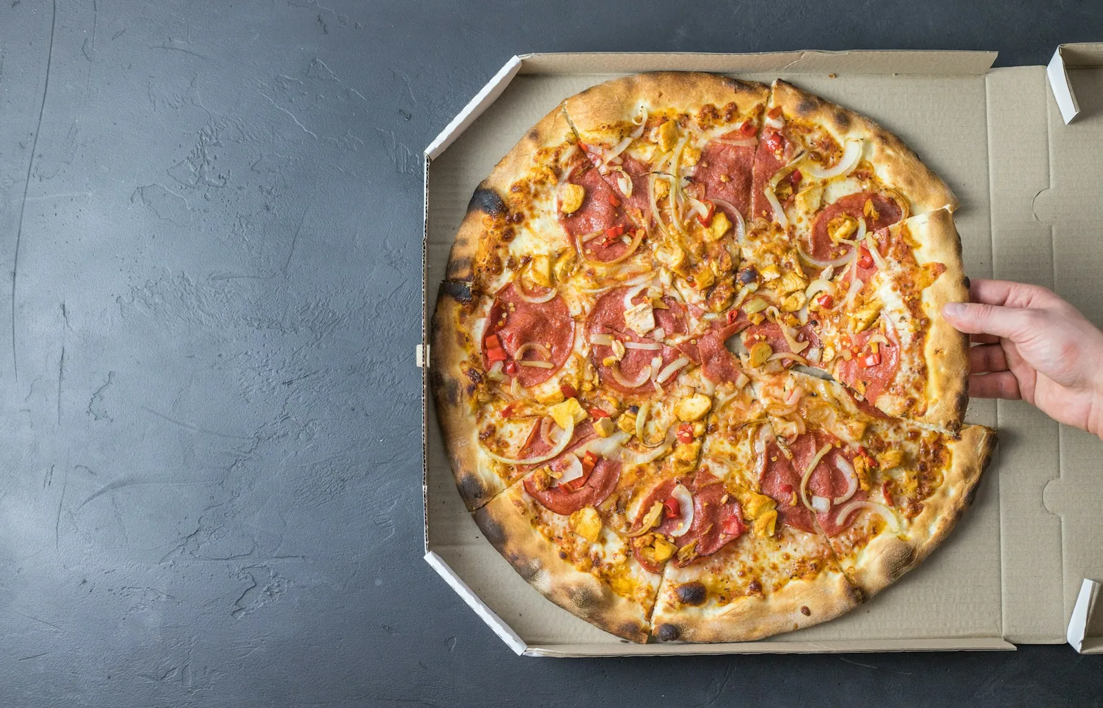 A single pizza slice on a dark background