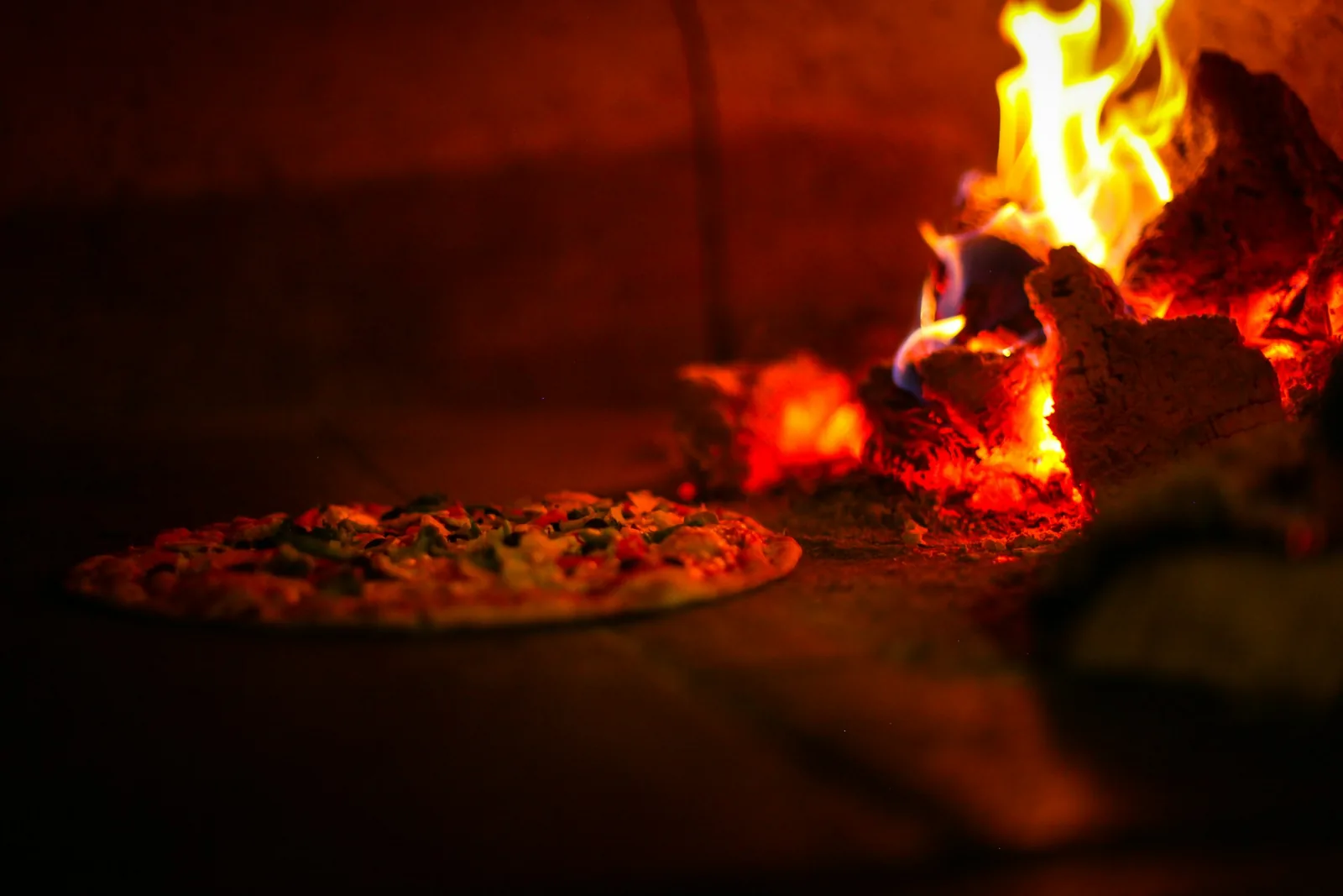 A pizza emerging from the oven