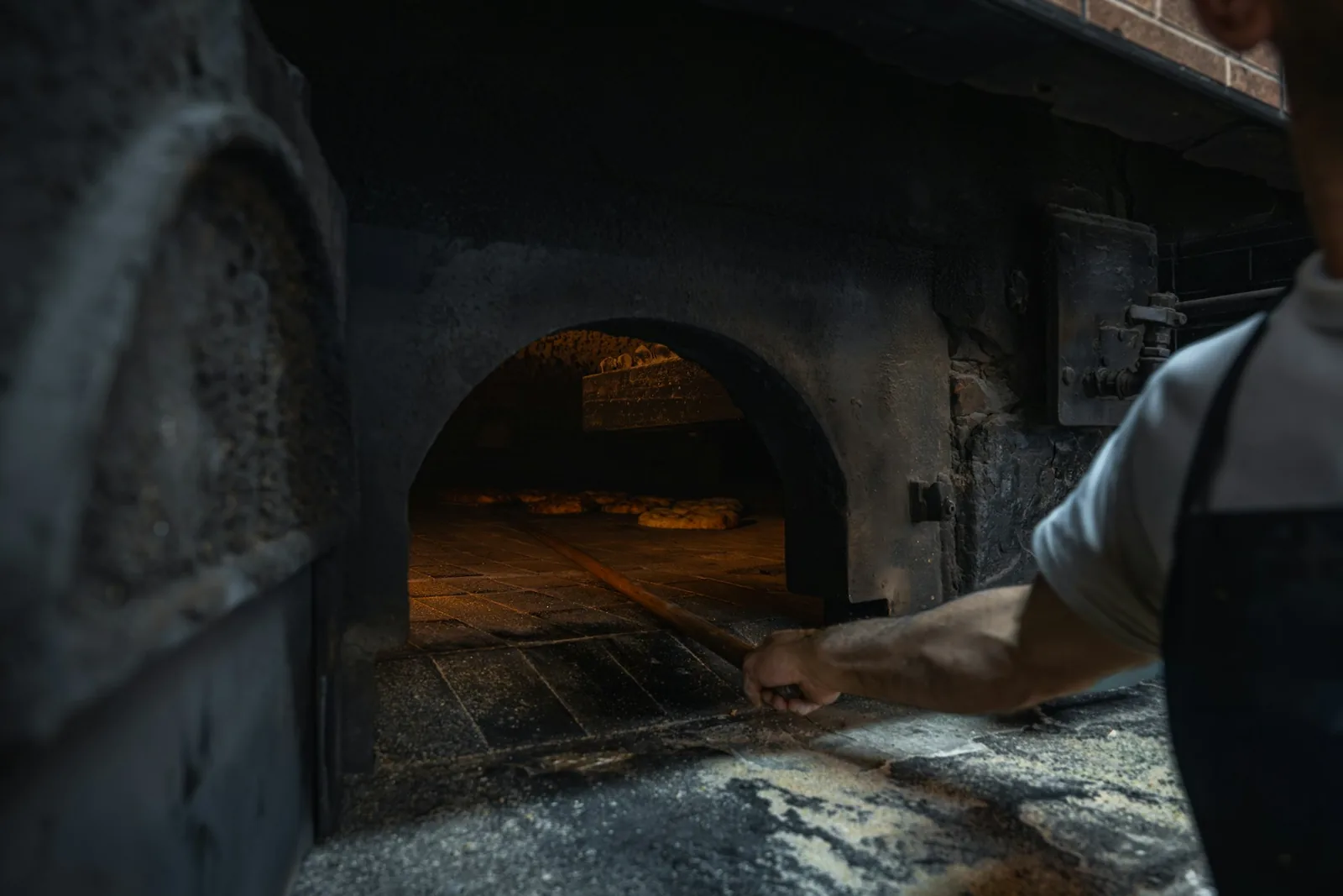 A pizza lit by an oven's glow