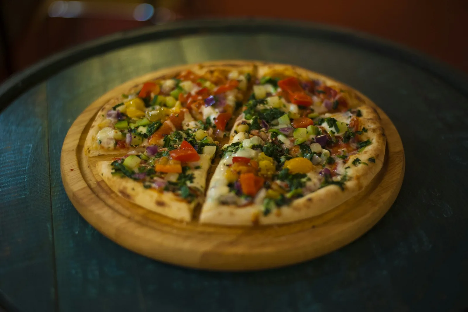 A whole vegetable pizza on a wooden board