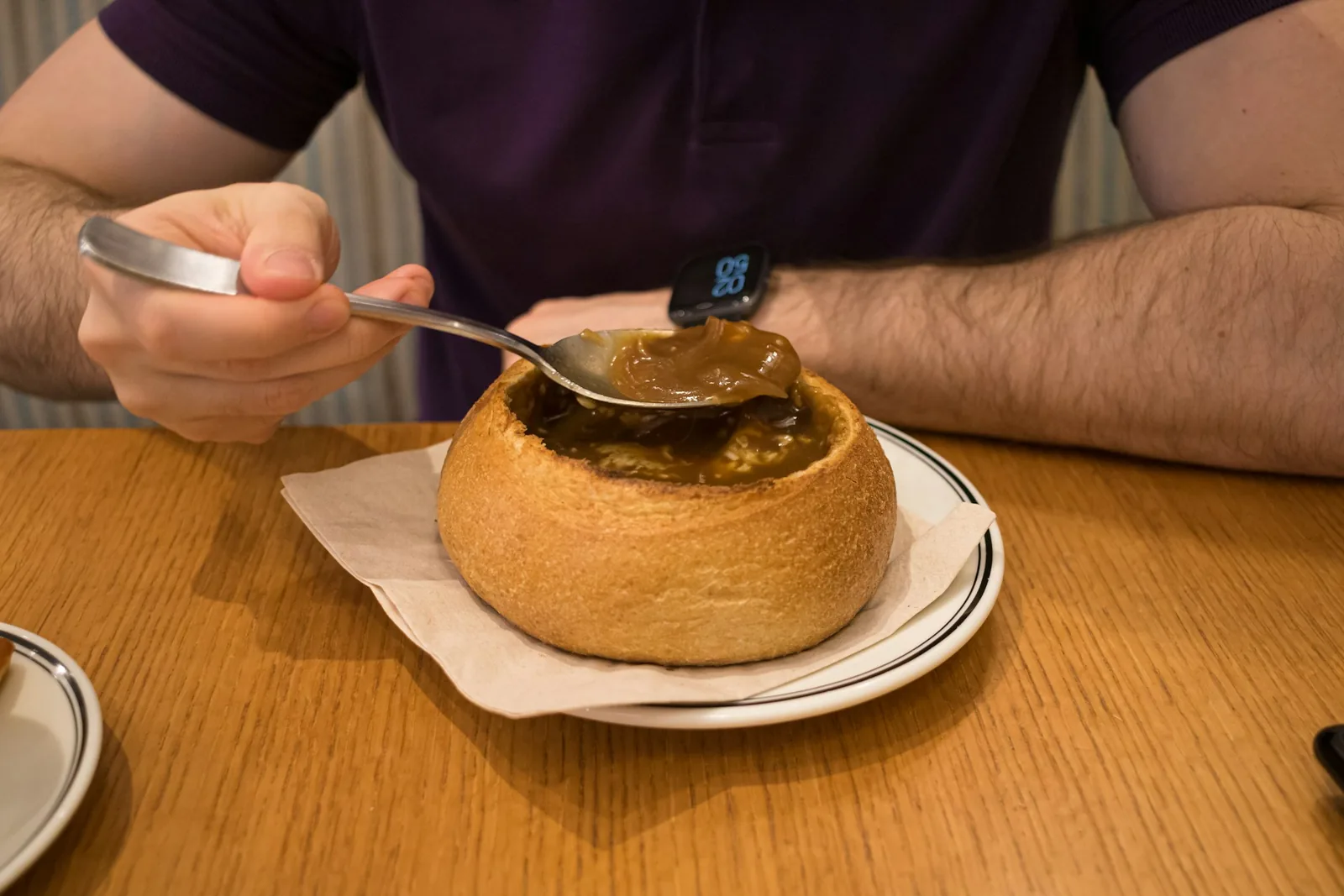 A spoon lifted from a bowl of soup