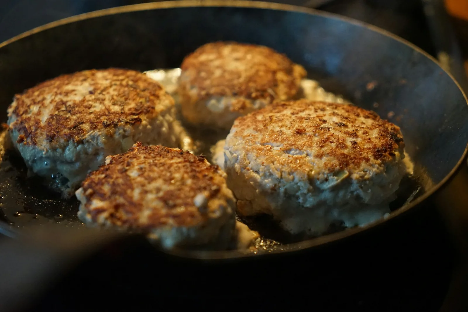 Meatballs browning in a pan