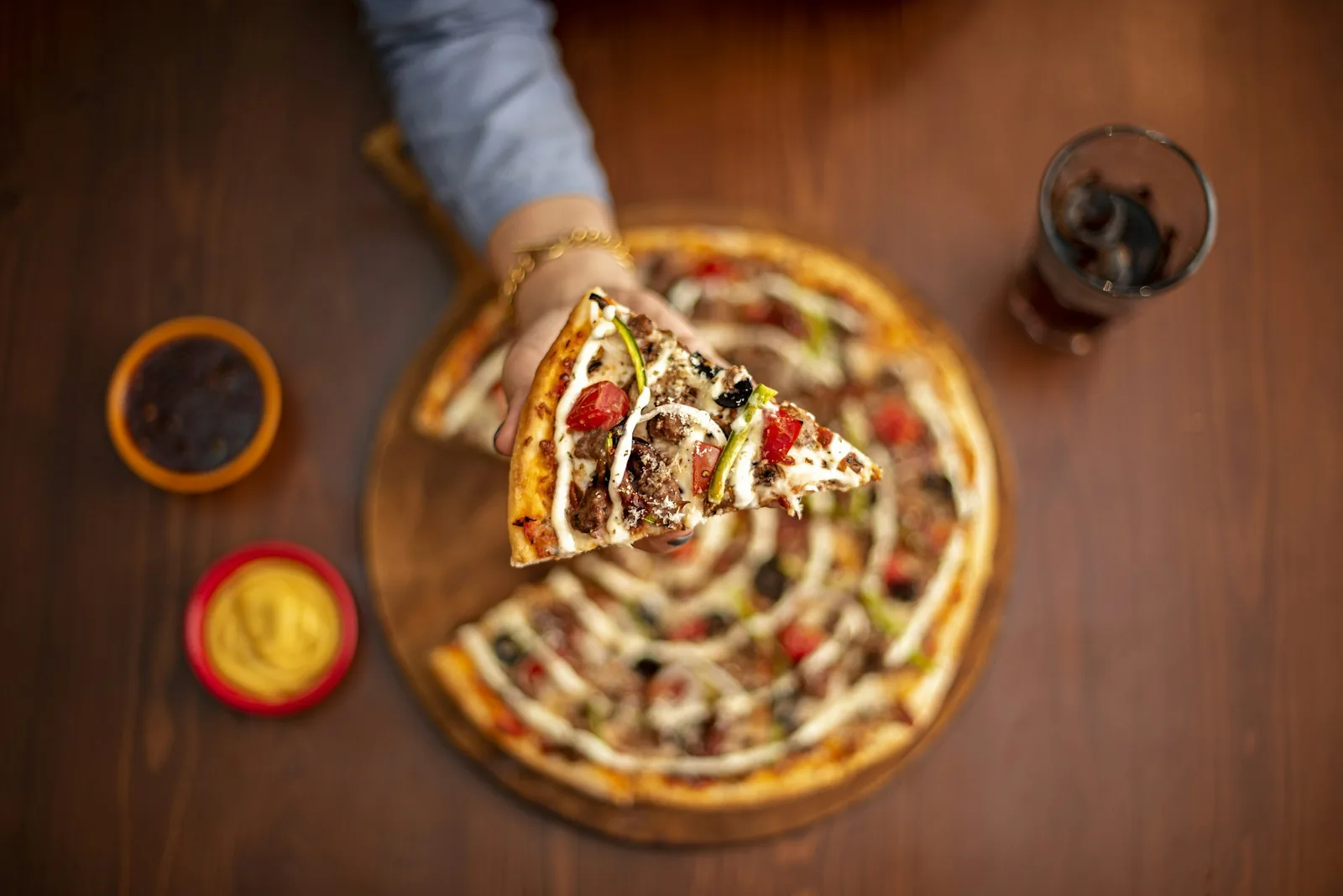 A slice being lifted from a shared pizza