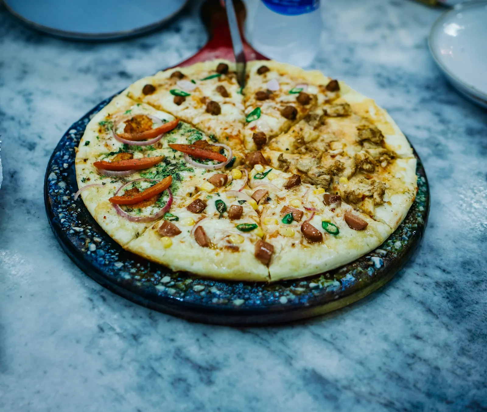A pizza topped with vegetables and herbs