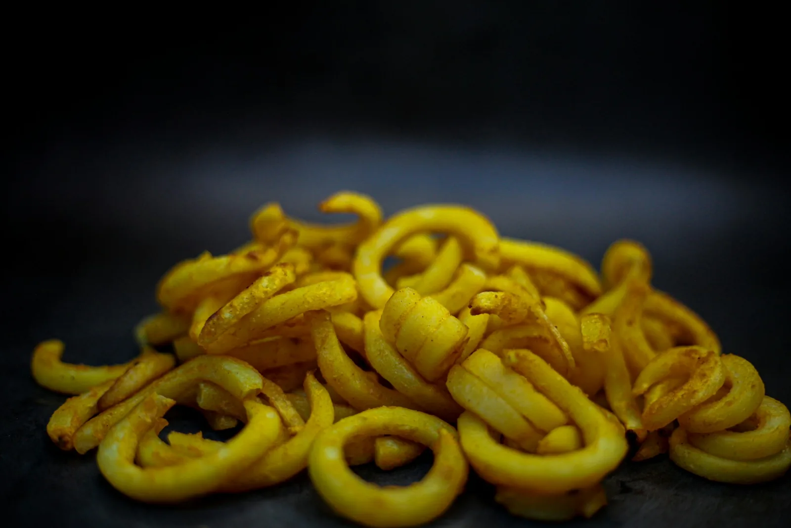 Curly fries on a dark background