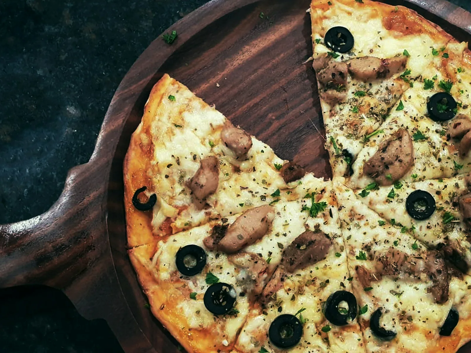 A pizza crust on a dark background