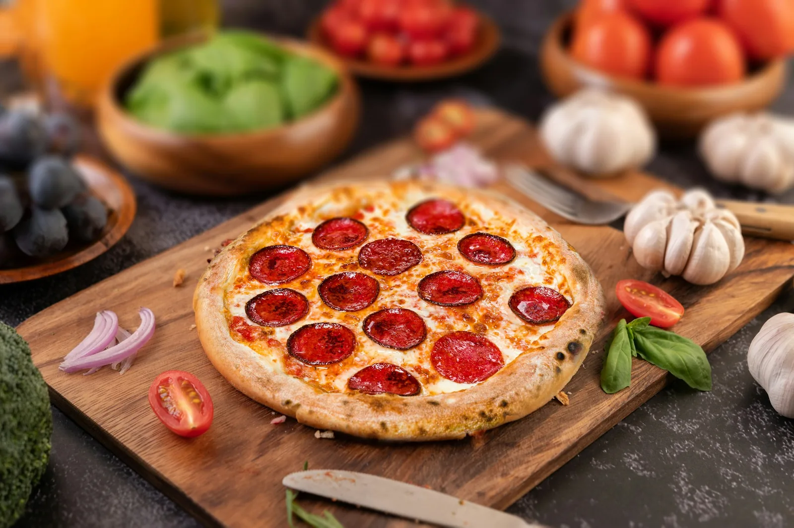 A pepperoni pizza on a board