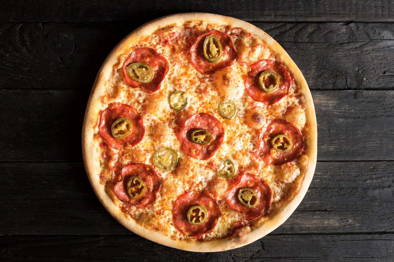 A pizza topped with cured sausage and chillies