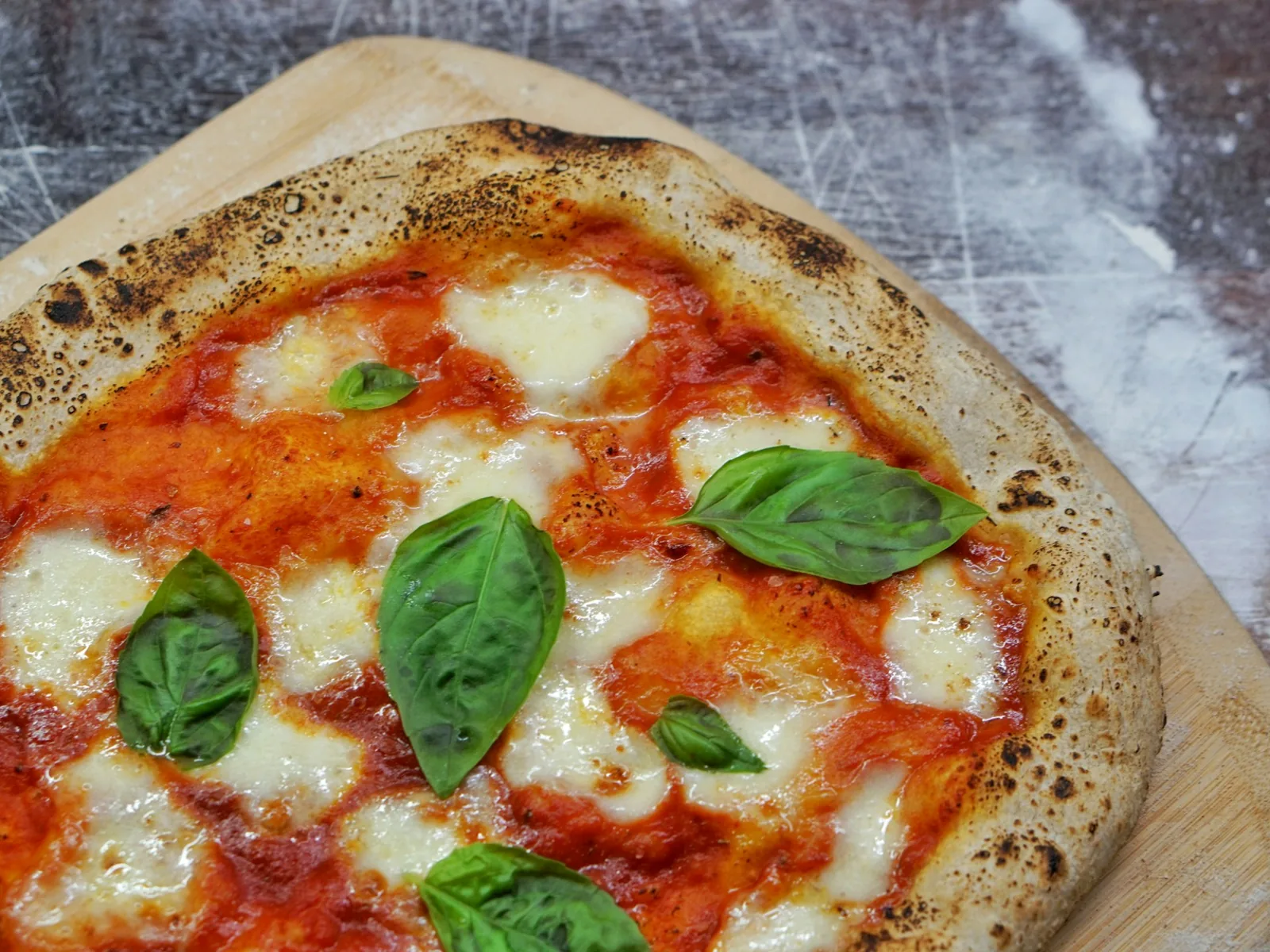 A pizza with basil in warm light