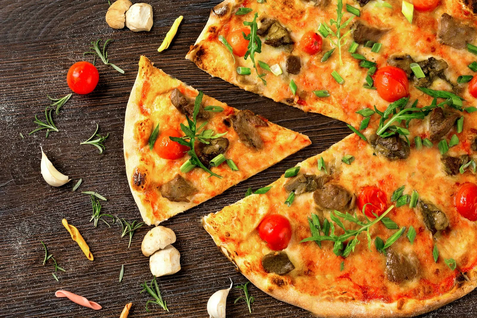 A pizza finished with fresh herbs