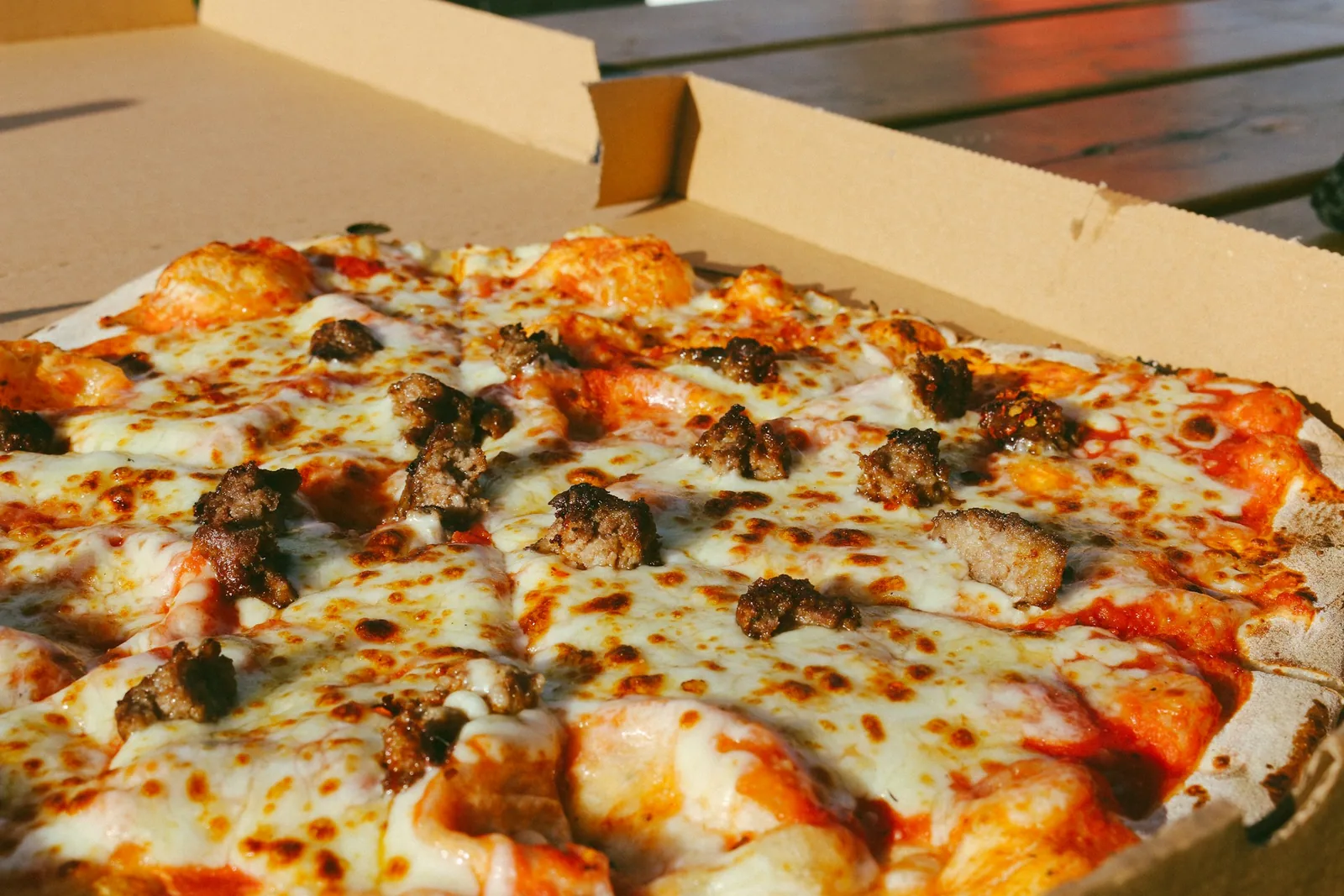 An open pizza box with a whole pizza inside