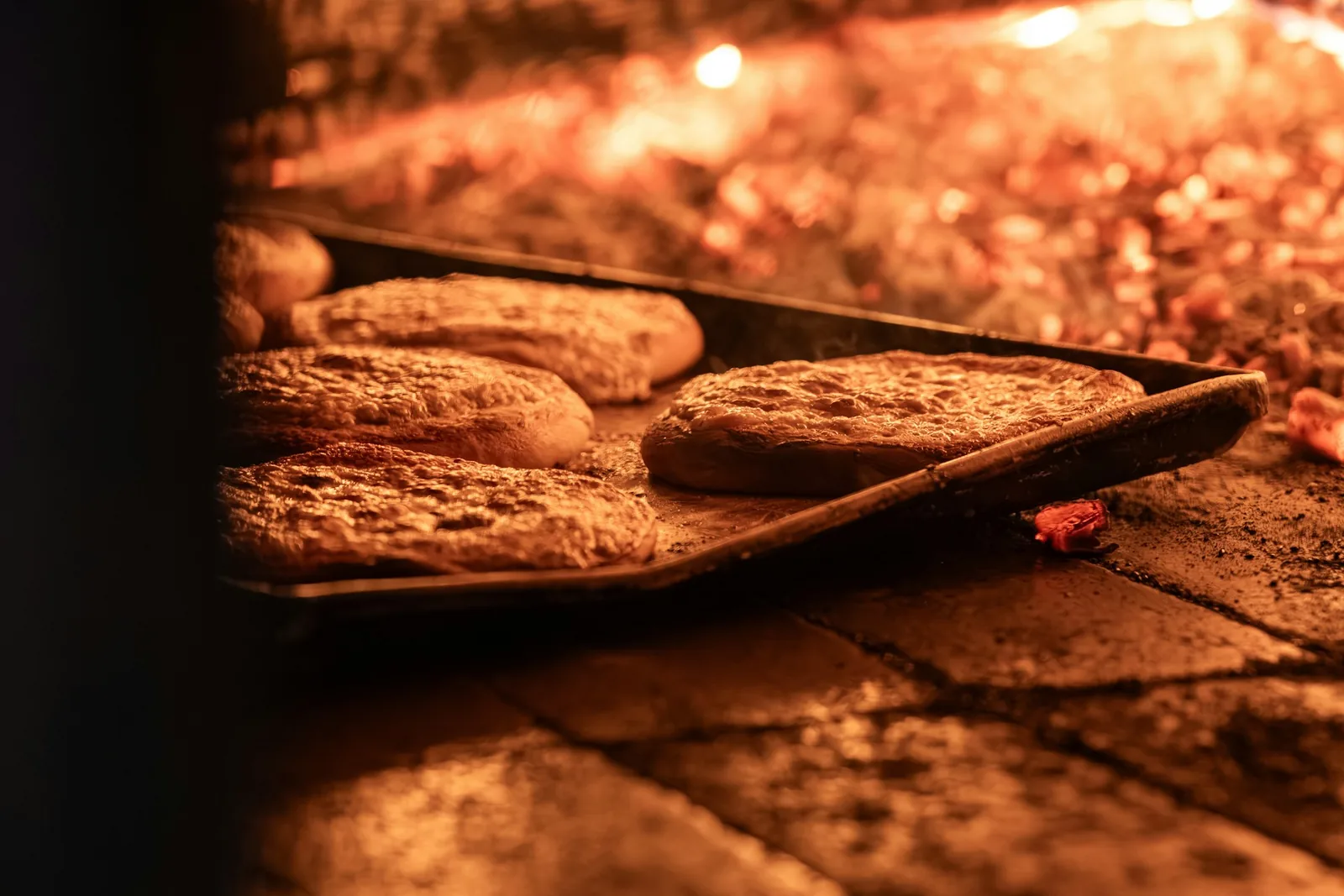 Flatbreads on a peel at the mouth of a wood-fired oven