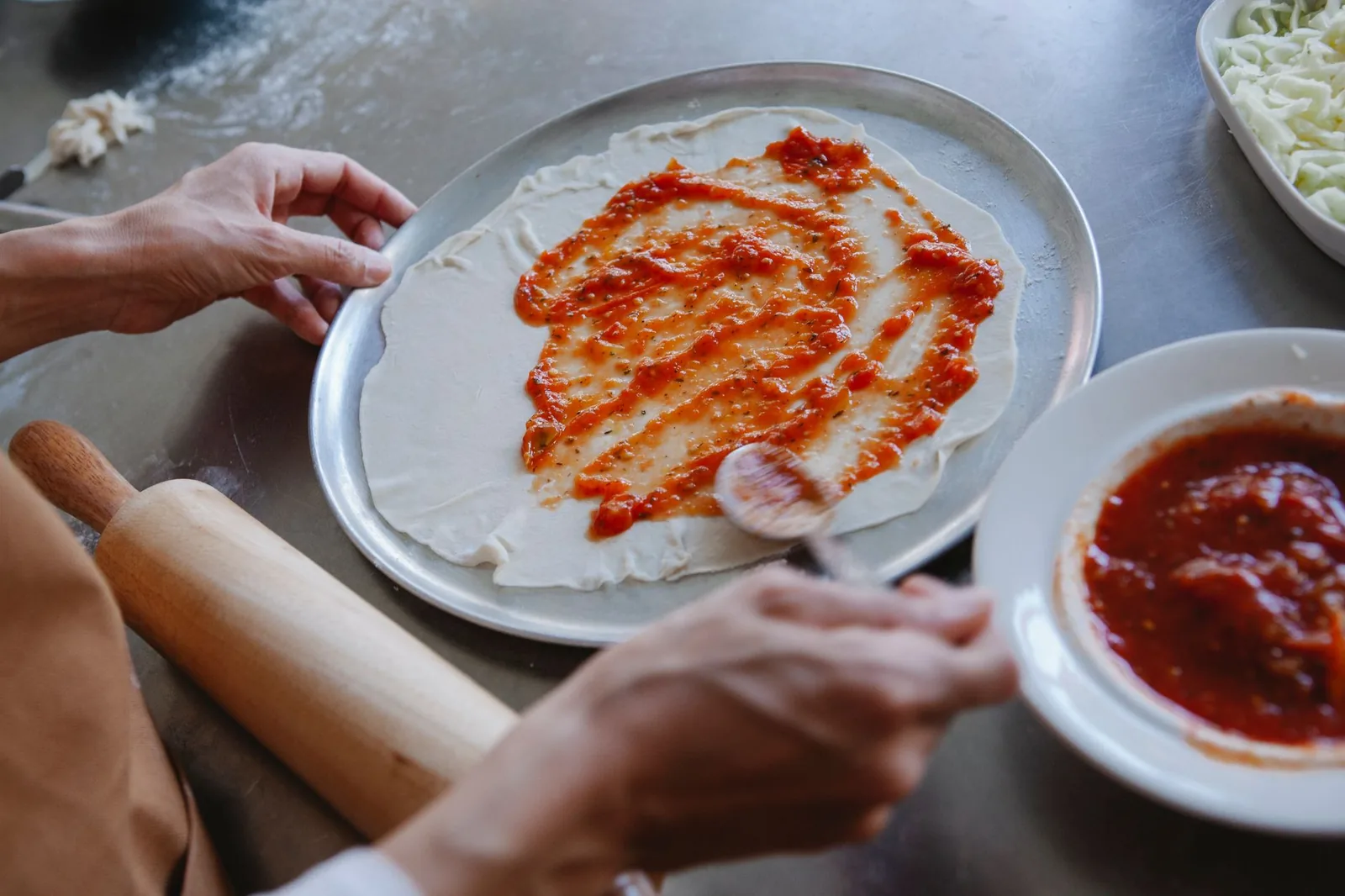 Sauce spread across a pizza base