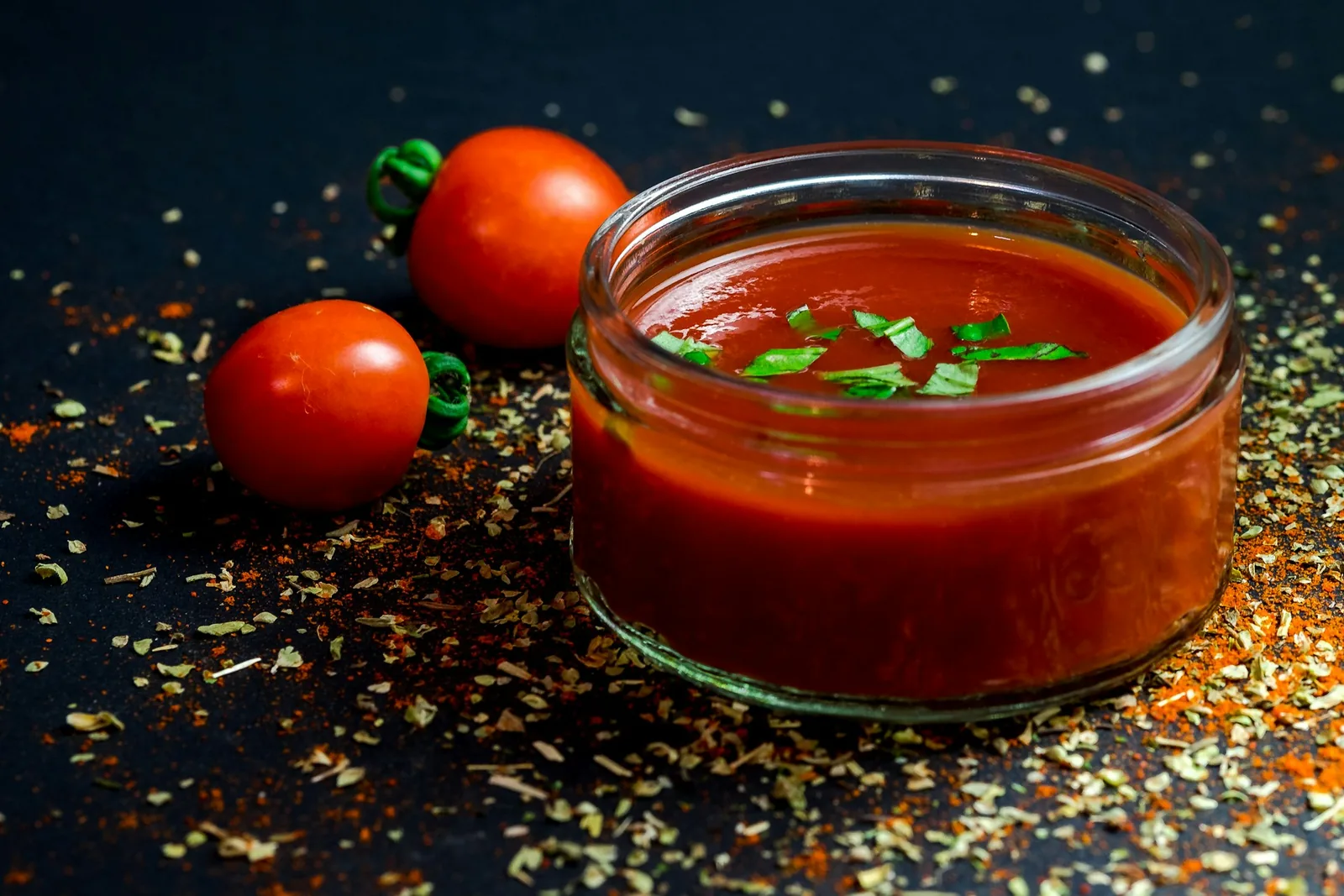 A bowl of tomato sauce on a dark background