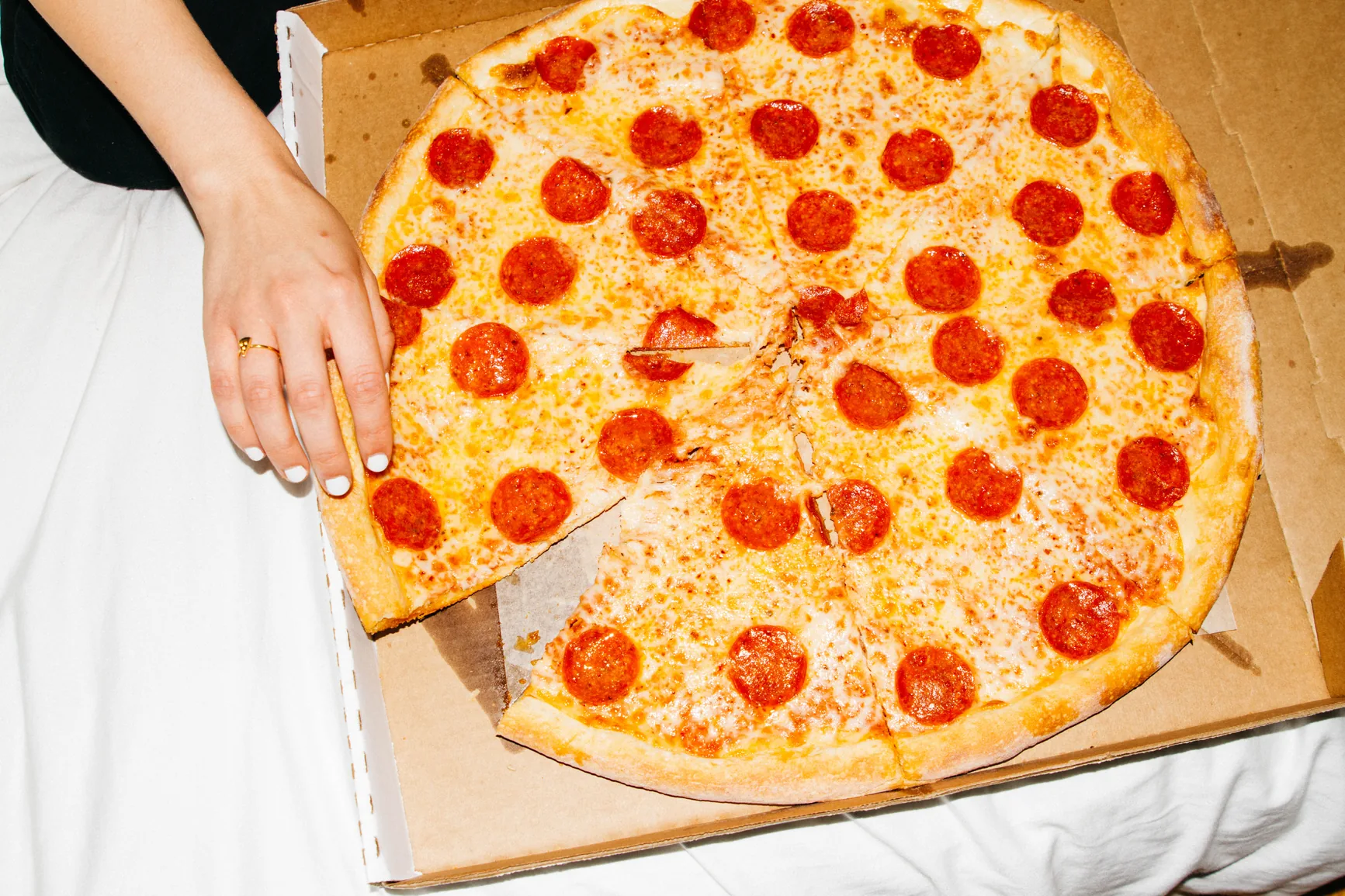 Whole pepperoni pizza being served