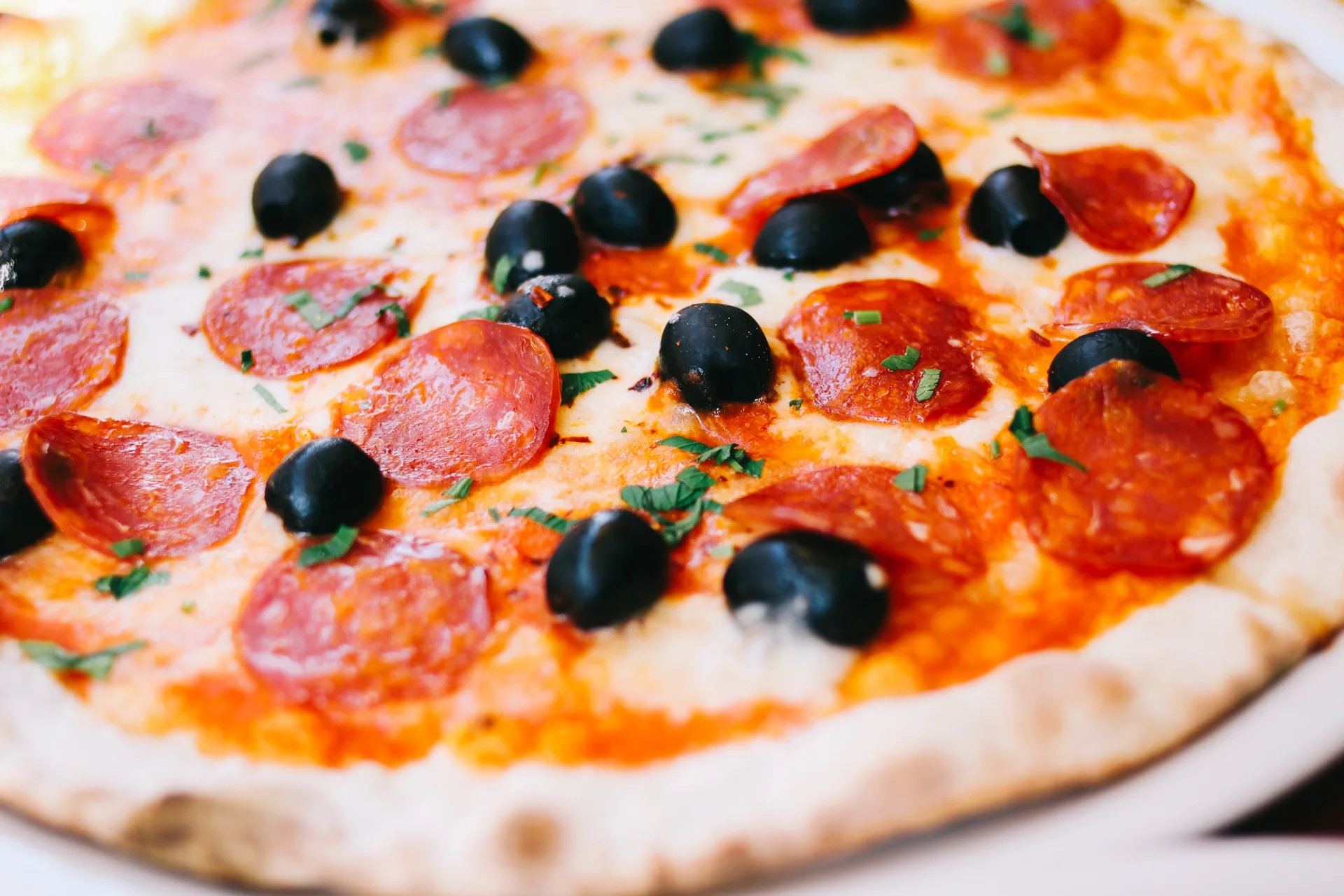 Whole pizza with pepperoni and black olives