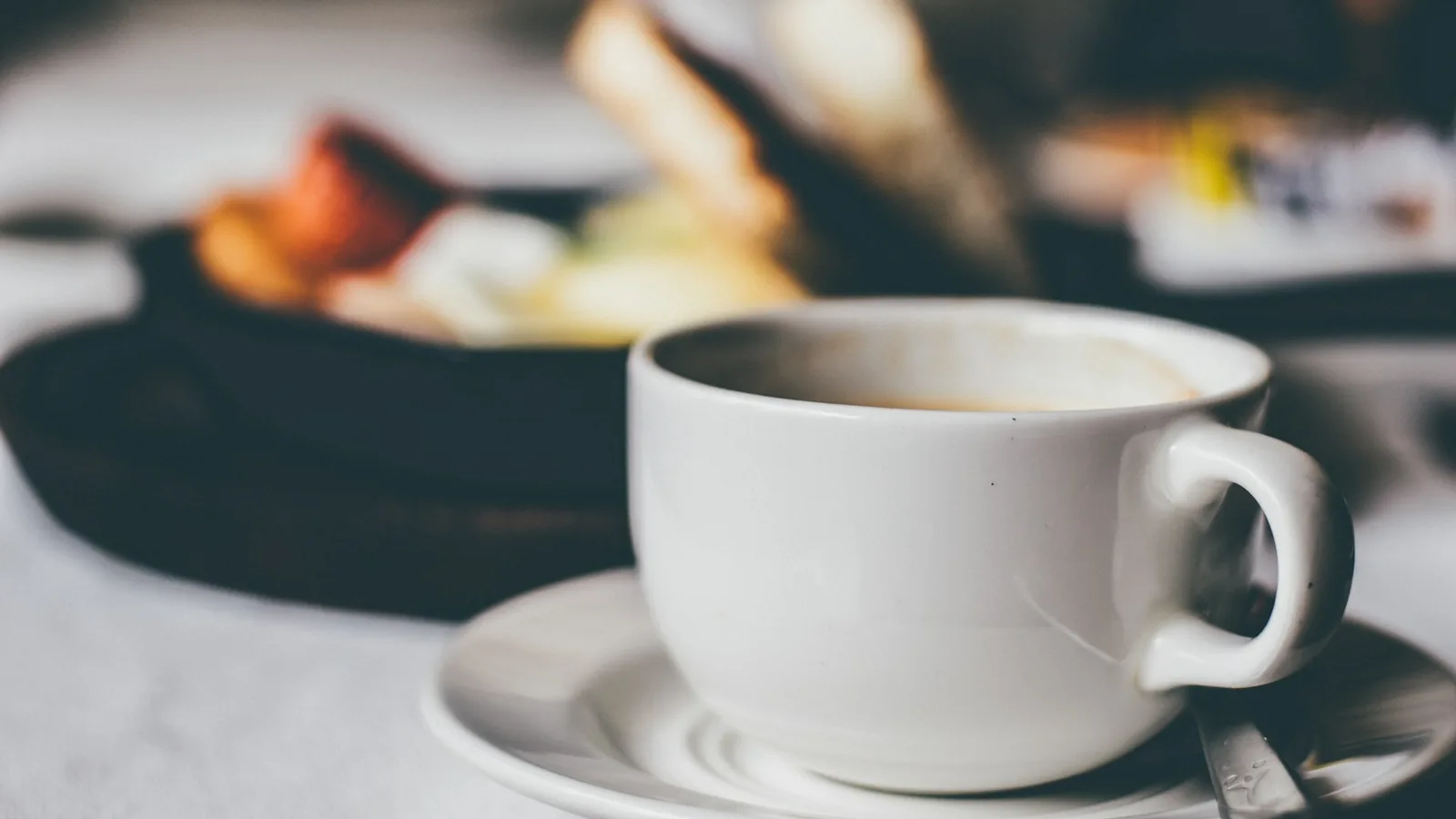 A coffee cup beside a plate