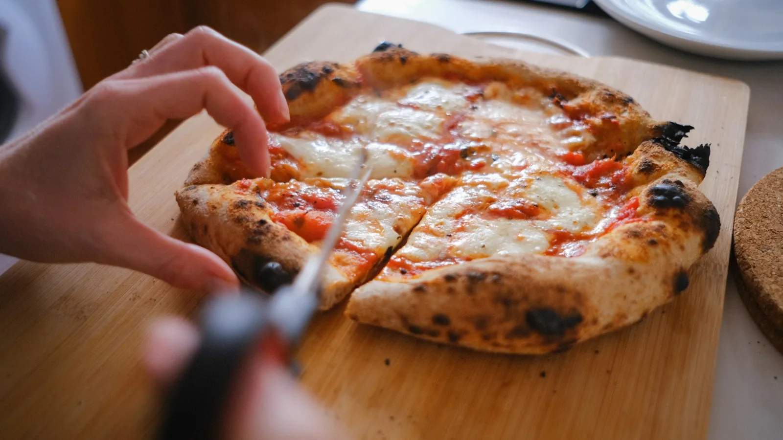 A pizza being cut with scissors
